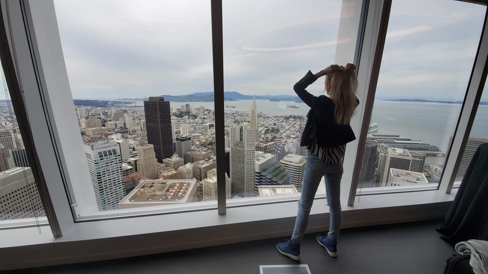 Sylvia Gorajek of America Unlocked at a high-rise window overlooking San Francisco, busting self-sponsored visa myths
