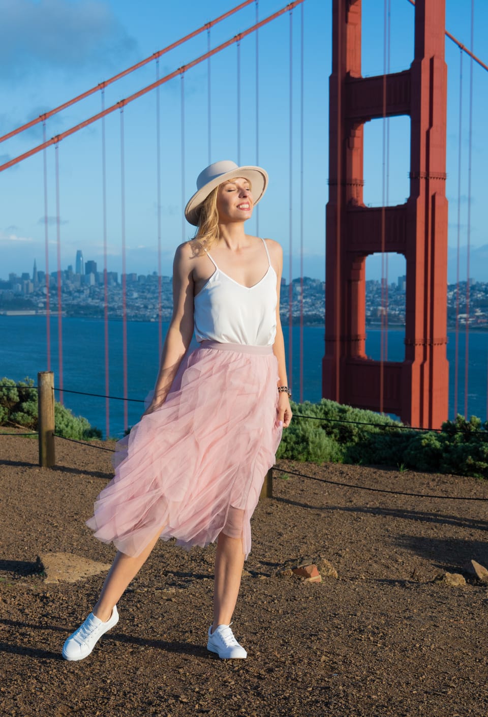 Sylvia Gorajek of America Unlocked in a sun hat at a Golden Gate Bridge viewpoint, on choosing between the O-1 and EB-1A with immigration attorney support